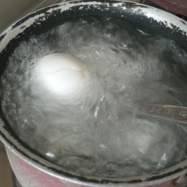 تخم مرغ شکسته نیمه غوطه ور آب جوش